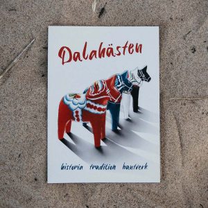 Framsida av boken "Dalahästen - historia tradition hantverk" illustrerad med fyra dalahästar